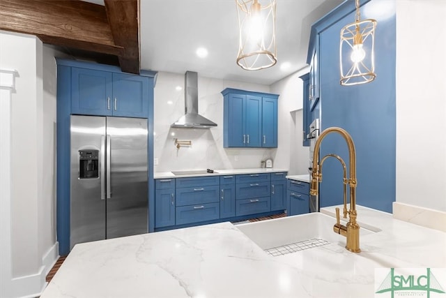 kitchen featuring stainless steel fridge with ice dispenser, blue cabinetry, wall chimney range hood, beam ceiling, and pendant lighting