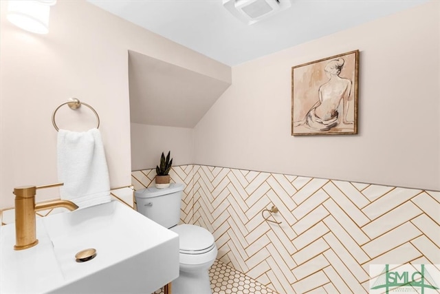 bathroom with sink, tile patterned floors, toilet, and tile walls