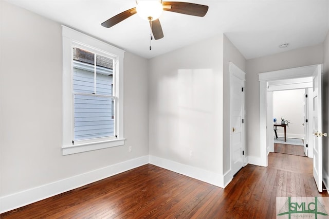 empty room featuring plenty of natural light, dark hardwood / wood-style floors, and ceiling fan