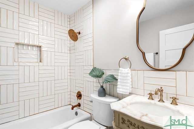 full bathroom featuring toilet, tiled shower / bath combo, tile walls, and sink