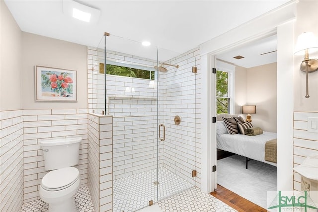 bathroom with tile walls, an enclosed shower, tile patterned floors, and toilet