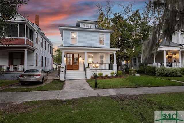 view of front facade with a lawn and covered porch