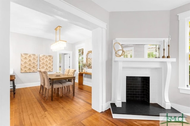 dining space with wood-type flooring and a fireplace