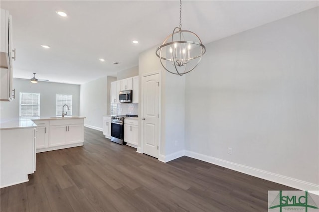 kitchen featuring tasteful backsplash, ceiling fan with notable chandelier, stainless steel appliances, pendant lighting, and white cabinets