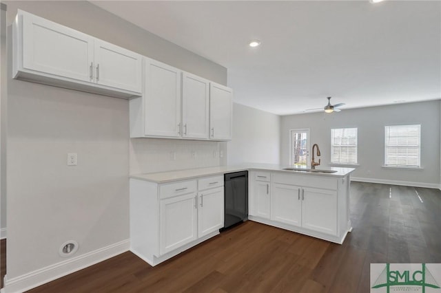 kitchen with kitchen peninsula, decorative backsplash, sink, dishwasher, and white cabinetry