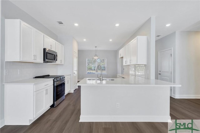 kitchen with kitchen peninsula, stainless steel appliances, sink, white cabinets, and hanging light fixtures