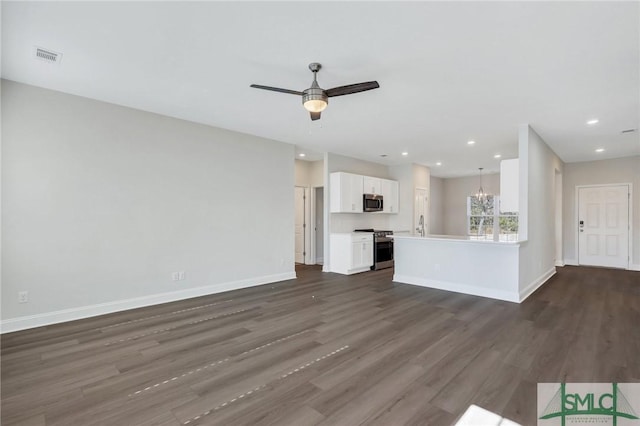 unfurnished living room with dark hardwood / wood-style floors and ceiling fan with notable chandelier