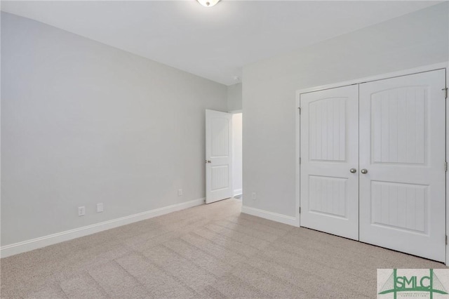 unfurnished bedroom with light carpet and a closet