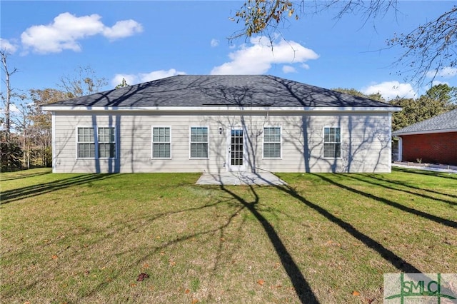 rear view of property featuring a lawn