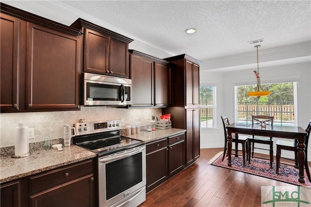 kitchen featuring pendant lighting, stainless steel appliances, dark wood-type flooring, and tasteful backsplash