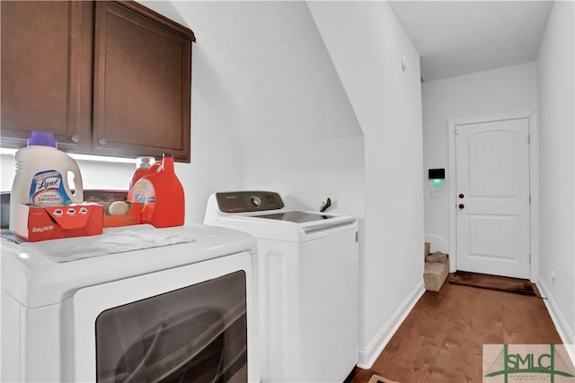 laundry room featuring cabinets, wood-type flooring, and washer and dryer