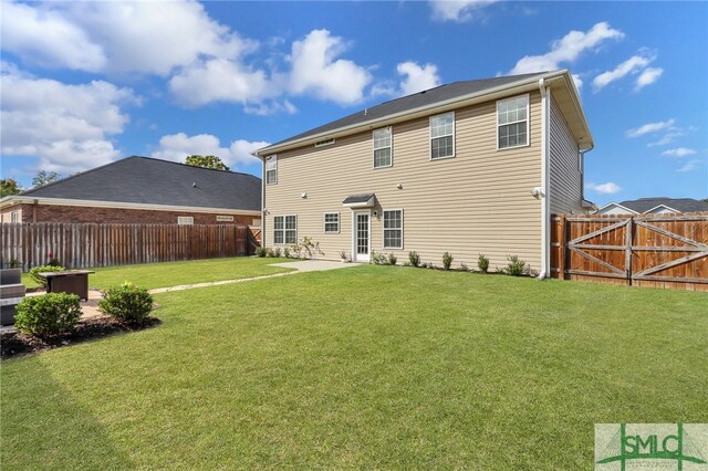 rear view of house featuring a patio area and a lawn