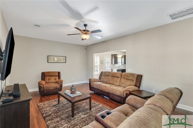 living room with dark hardwood / wood-style floors and ceiling fan