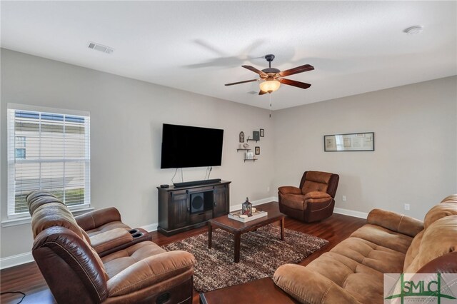 living room featuring dark wood-type flooring and ceiling fan