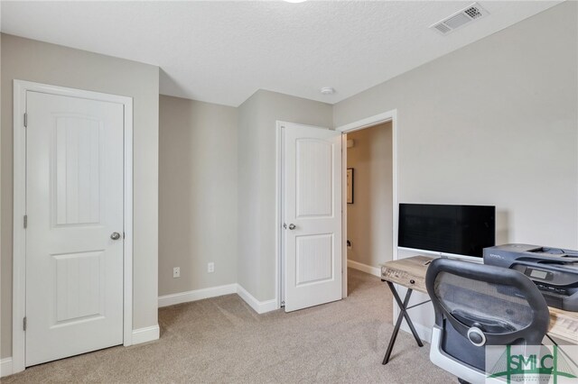 office area featuring light colored carpet and a textured ceiling