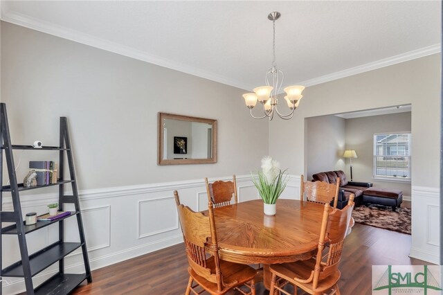 dining space with ornamental molding, dark wood-type flooring, and a chandelier