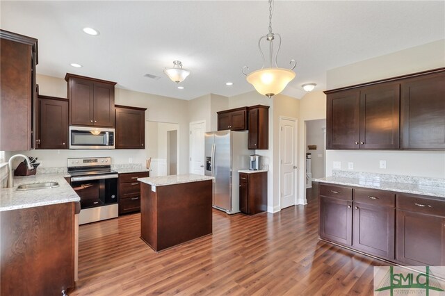 kitchen featuring a center island, sink, dark hardwood / wood-style floors, appliances with stainless steel finishes, and decorative light fixtures