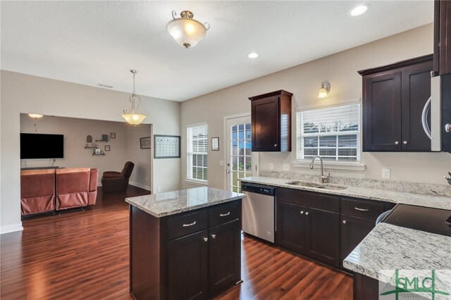 kitchen with sink, appliances with stainless steel finishes, dark hardwood / wood-style floors, a kitchen island, and pendant lighting