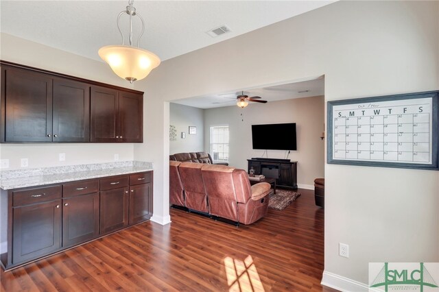 kitchen featuring dark brown cabinetry, hanging light fixtures, dark hardwood / wood-style floors, and ceiling fan