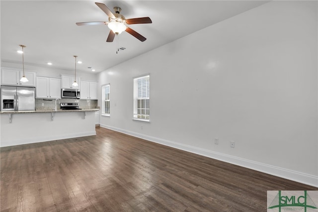 unfurnished living room featuring dark hardwood / wood-style flooring, ceiling fan, and sink