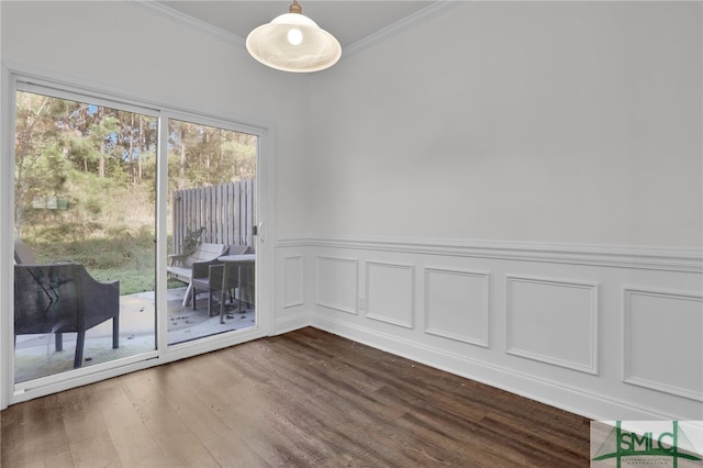 empty room featuring wood-type flooring, ornamental molding, and a healthy amount of sunlight