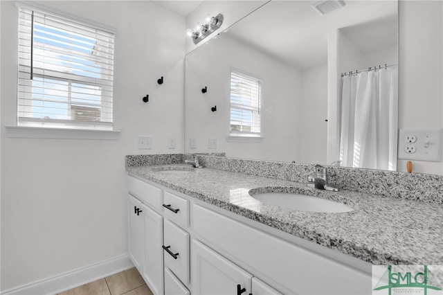 bathroom featuring vanity, a healthy amount of sunlight, and tile patterned flooring