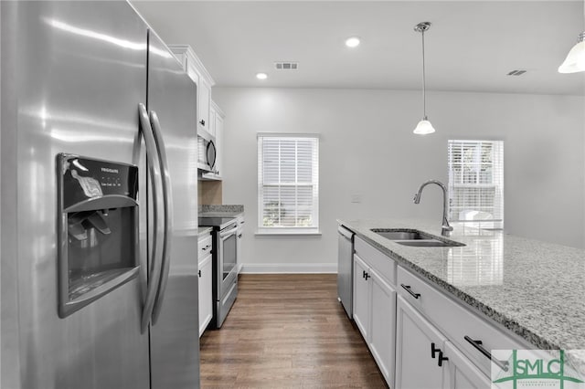 kitchen with white cabinetry, sink, appliances with stainless steel finishes, dark wood-type flooring, and light stone countertops