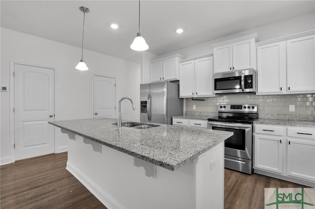 kitchen featuring sink, white cabinets, hanging light fixtures, and appliances with stainless steel finishes