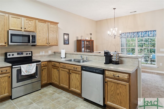 kitchen with stainless steel appliances, sink, kitchen peninsula, decorative light fixtures, and a notable chandelier