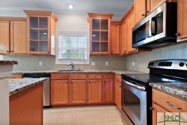 kitchen with crown molding, sink, light stone counters, and appliances with stainless steel finishes