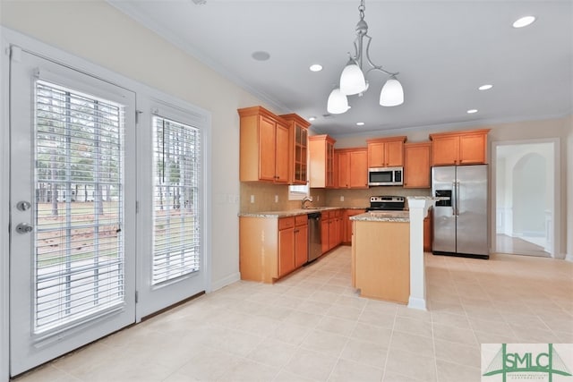 kitchen featuring plenty of natural light, a center island, pendant lighting, and stainless steel appliances