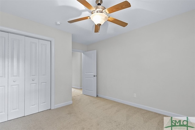 unfurnished bedroom featuring light carpet, ceiling fan, and a closet