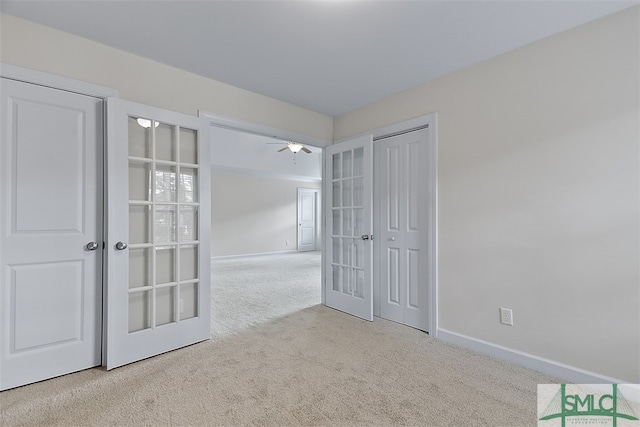 unfurnished room with ceiling fan, light carpet, and french doors