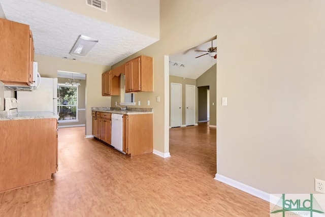 kitchen featuring light wood-style flooring, ceiling fan with notable chandelier, white appliances, visible vents, and baseboards