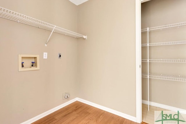 washroom with hookup for a washing machine, hookup for an electric dryer, wood finished floors, laundry area, and baseboards