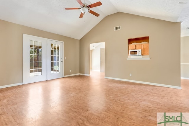 unfurnished living room with french doors, a textured ceiling, high vaulted ceiling, light hardwood / wood-style floors, and ceiling fan