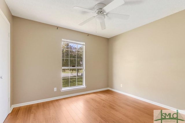 spare room with ceiling fan, light wood-type flooring, and baseboards