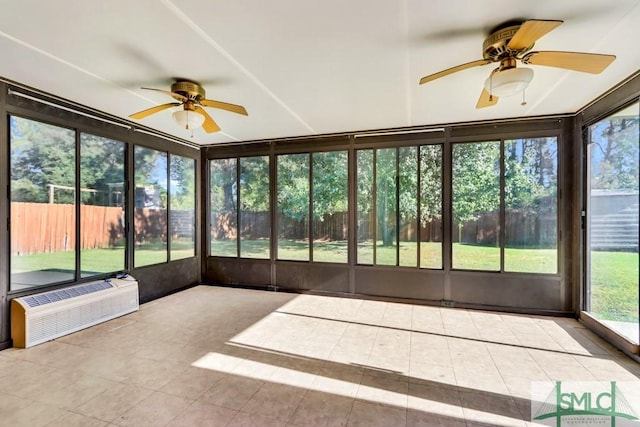 unfurnished sunroom with a wall unit AC, a healthy amount of sunlight, and ceiling fan