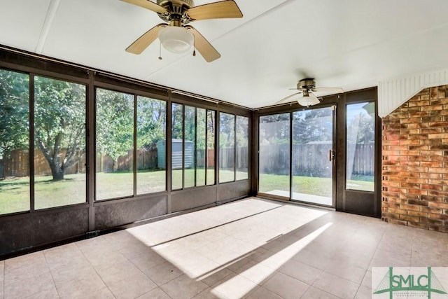 unfurnished sunroom featuring a ceiling fan