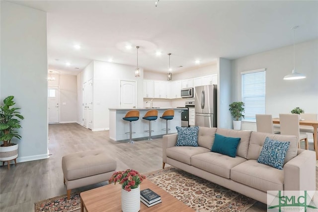 living room with sink and light hardwood / wood-style flooring