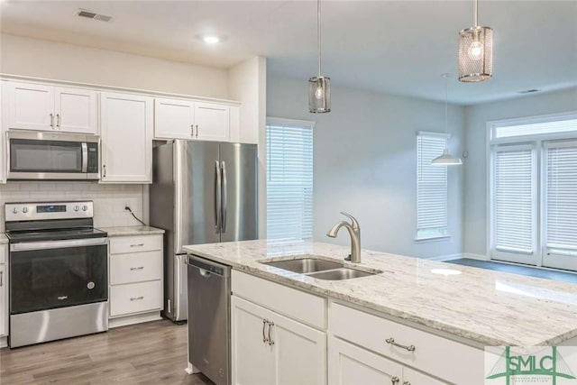24 Pomona Cir, Savannah, GA 31419 - kitchen featuring appliances with stainless steel finishes, wood finished floors, white cabinetry, pendant lighting, and decorative backsplash
