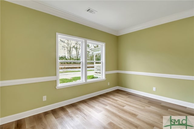 spare room featuring light hardwood / wood-style floors and ornamental molding