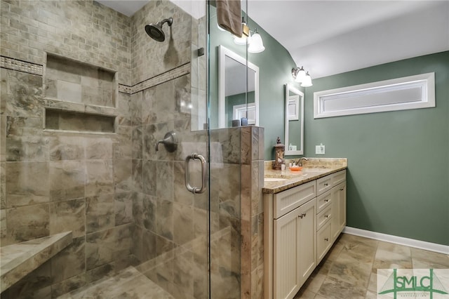 bathroom featuring a shower with door and vanity