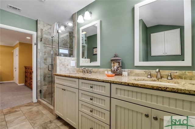 bathroom with vanity, vaulted ceiling, and a shower with door