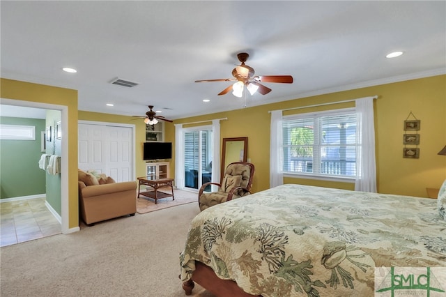 bedroom featuring ornamental molding, a closet, light colored carpet, and ceiling fan