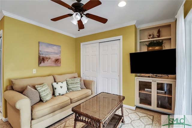 living room with ornamental molding, light carpet, and ceiling fan