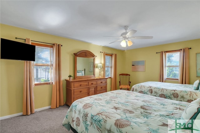 carpeted bedroom featuring multiple windows and ceiling fan