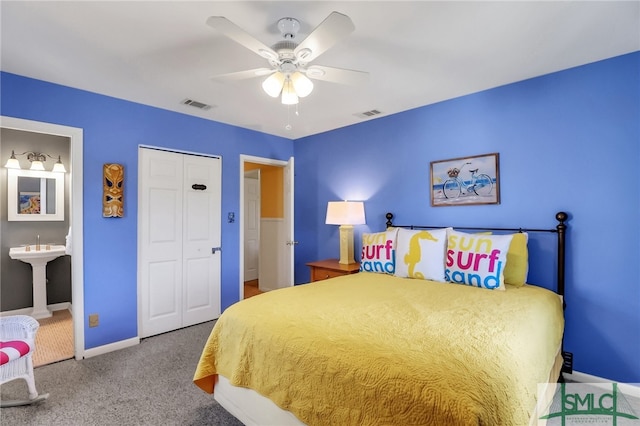 carpeted bedroom featuring ensuite bath, ceiling fan, sink, and a closet