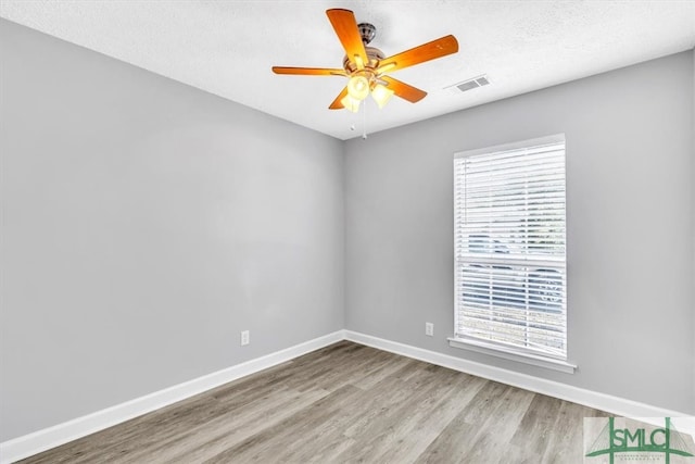 empty room featuring ceiling fan, a textured ceiling, and light hardwood / wood-style flooring