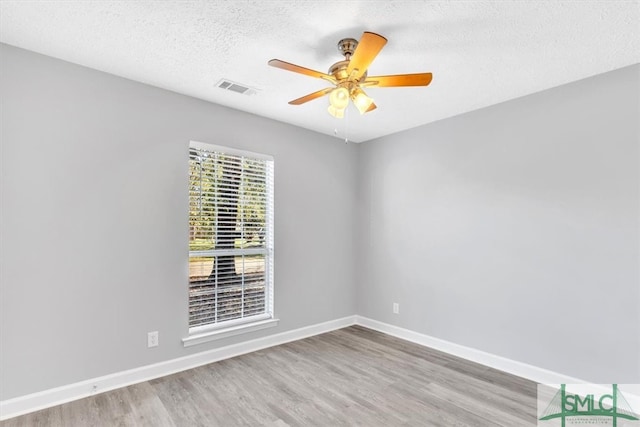 unfurnished room featuring light hardwood / wood-style floors, ceiling fan, and a textured ceiling